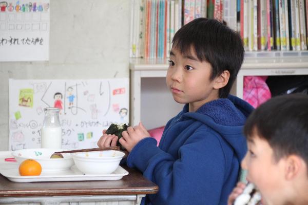 おむすびを食べながら真剣に話を聞く千早小吹台小学校2年生