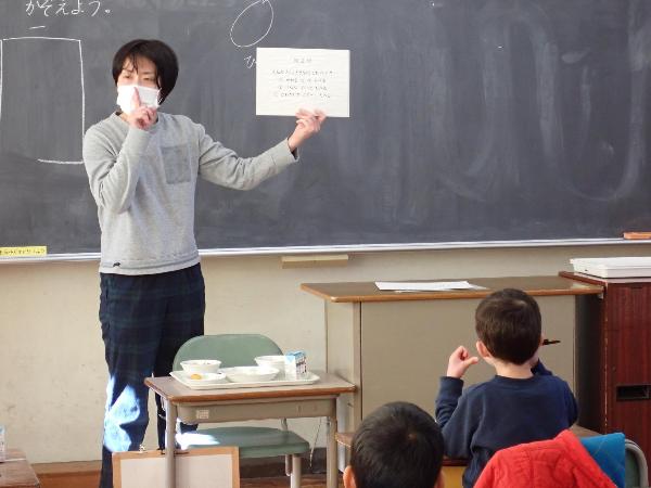 静かな声で給食時間を過ごすよう指導する栄養教諭