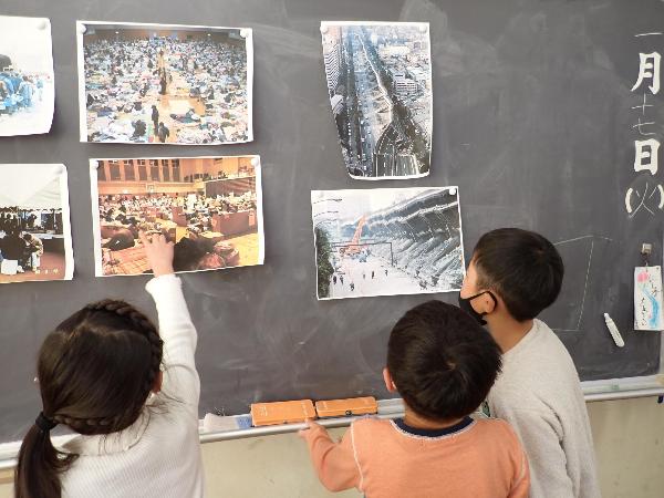 震災の写真を見て、色々質問をする千早小吹台小学校2年生