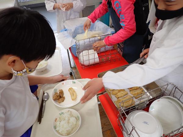 バナナの天ぷらを配膳する千早小吹台小学校3年生