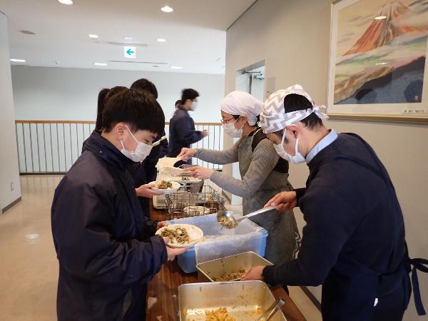 くすのきホールで給食を配膳する中学1年生