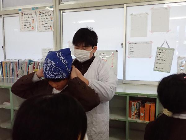 5年生の三角巾を結んであげる6年生