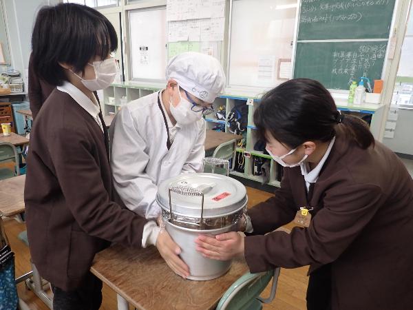 温かい汁物の食缶に触れる、赤阪小学校6年生