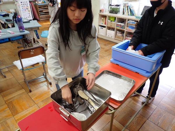 中学校給食の片付け方の練習をする千早小吹台小学校6年生