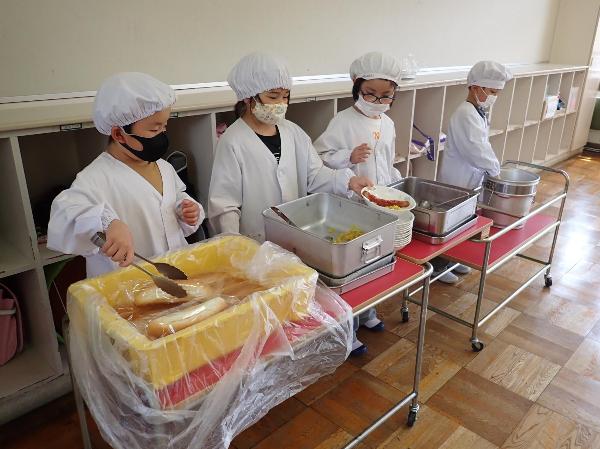 配膳台の後ろでスタンバイする千早小吹台小学校1年生