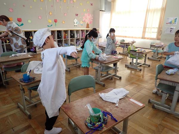 給食エプロンを着る千早小吹台小学校1年生