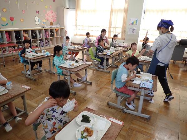 から揚げのおかわりをもらう千早小吹台小学校1年生