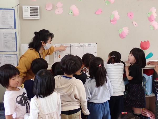 給食当番の分担を教えてもらう千早小吹台小学校1年生