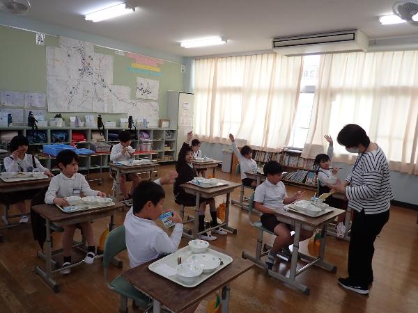 わかめご飯のおかわりに手を挙げる赤阪小学校3年生