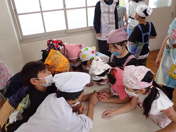 豆を食べている虫を観察する千早小吹台小学校3.4年生