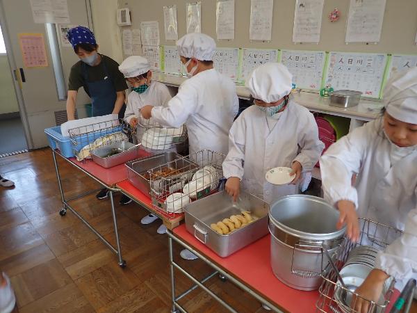 エプロンをきちんと着て配膳をする千早小吹台小学校3年生