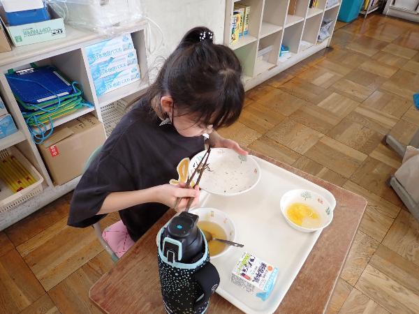 がんばってお箸でひじきずしを食べる千早小吹台小学校4年生