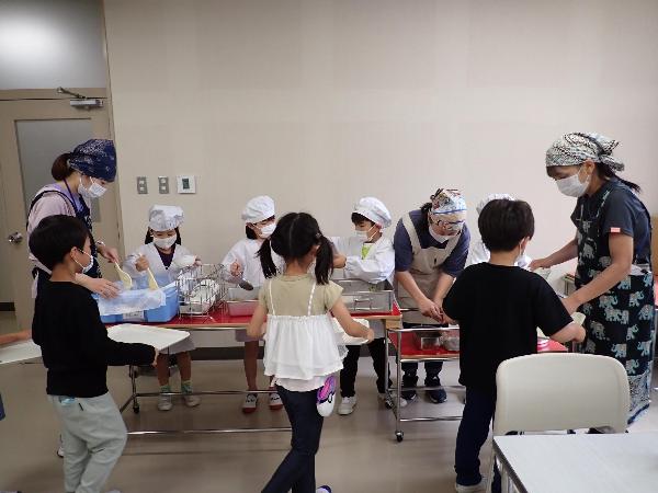 給食センターの会議室で給食の配膳をする千早小吹台小学校1年生