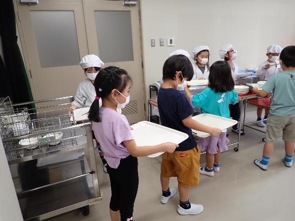 給食センターの会議室で給食の配膳をする千早小吹台小学校1年生