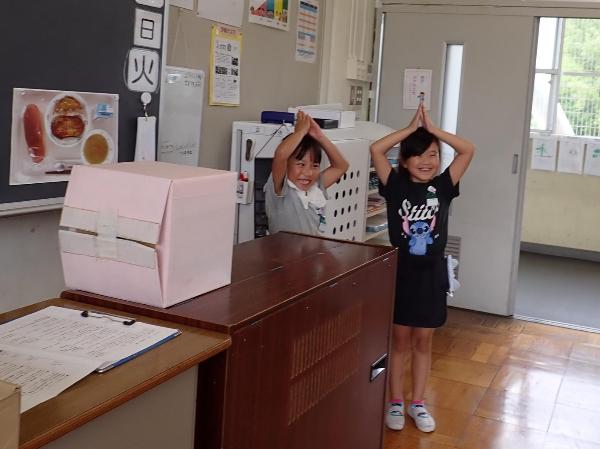 ひみつボックスの中の野菜のヒントをジェスチャーする千早小吹台小学校2年生