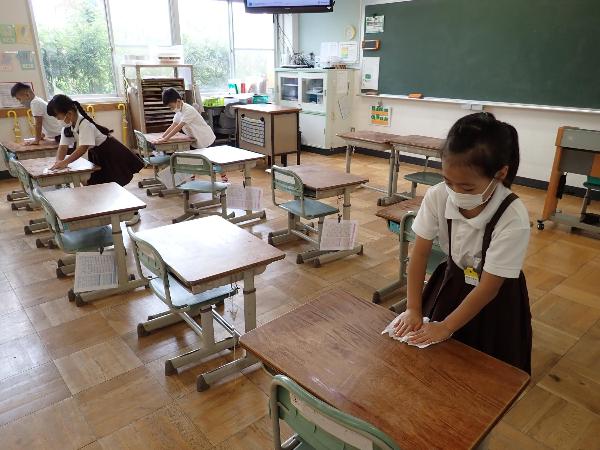 机の消毒をする赤阪小学校1年生