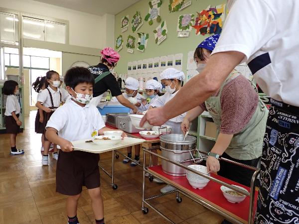 慎重に給食を配膳する赤阪小学校1年生
