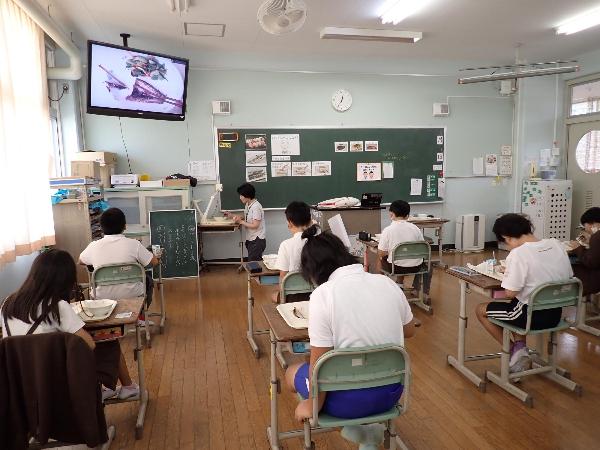 書画カメラで映したいわしを見ながら実践する赤阪小学校5年生