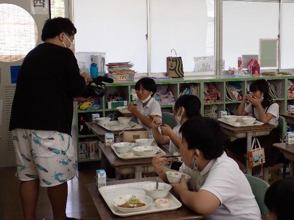 オオクボールを食べながら取材を受ける赤阪小学校3年生