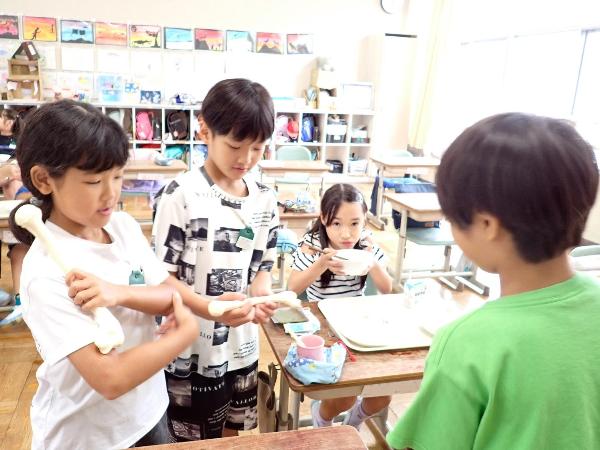 子どもの骨の模型と大人の骨の模型を比べる千早小吹台小学校3年生