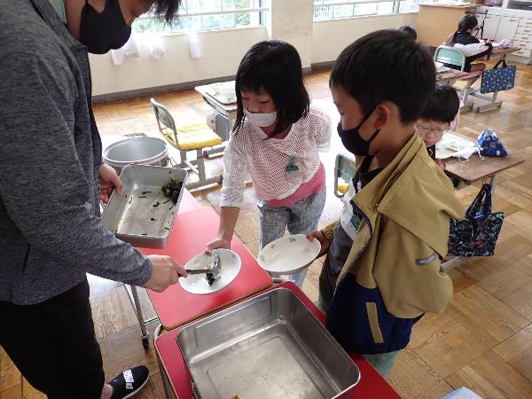 野菜のおかずをおかわりに来る千早小吹台小学校3年生