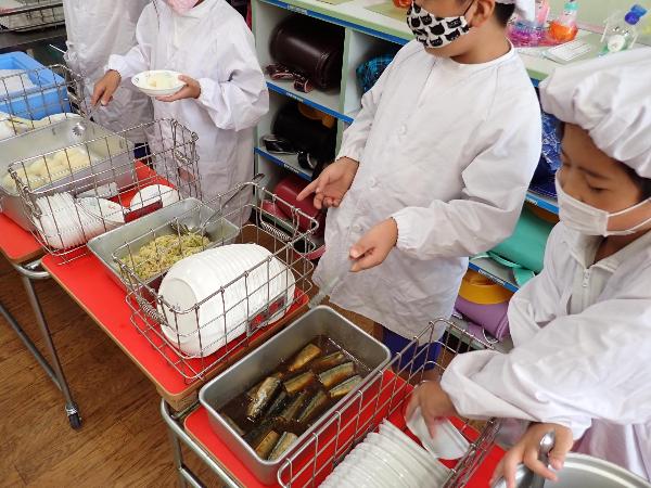 いわしのしょうが煮を配膳する赤阪小学校3年生