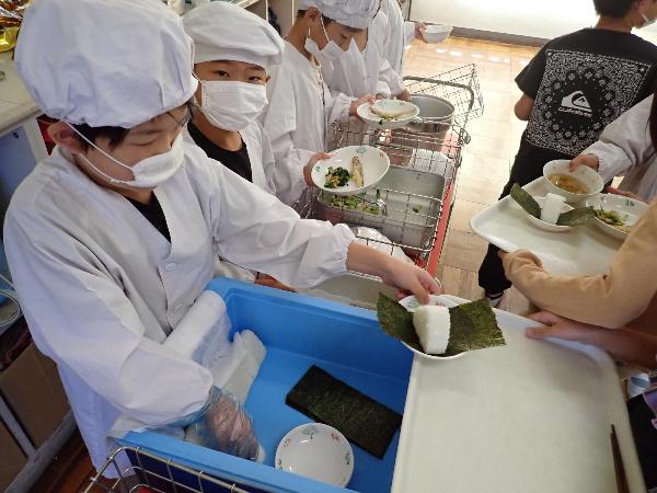 上手におにぎりを配膳する千早小吹台小学校3年生