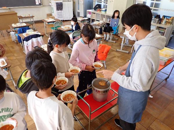 ポークビーンズの追加盛りに集まる千早小吹台小学校4年生