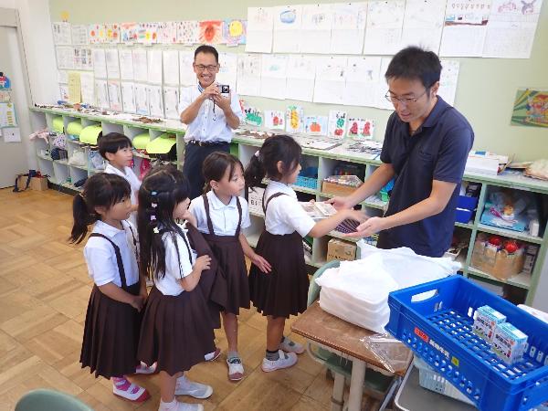 担任の先生からお弁当給食を受け取る、赤阪小学校児童