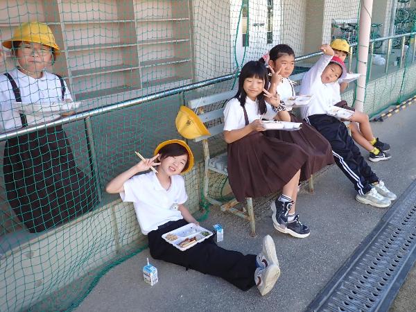 教室を出て、外でお弁当給食を食べる赤阪小学校児童