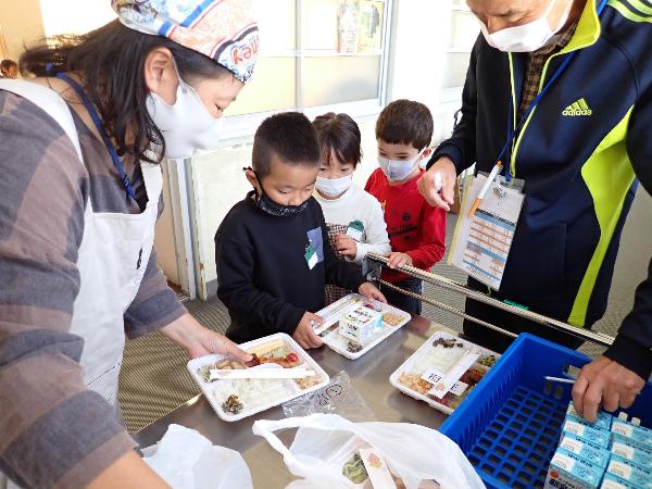 興味津々に弁当を受け取る千早小吹台小1年生