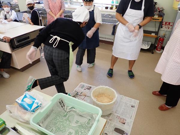 みそ玉を樽に投げ入れて空気を抜くようす