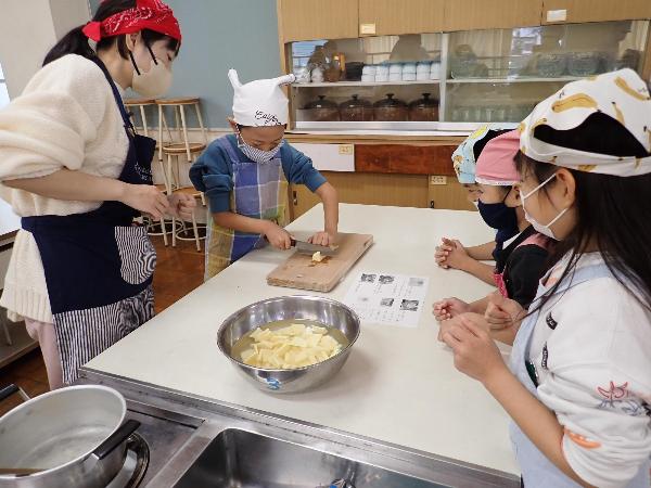 包丁で慎重にさつまいもを切る1年生