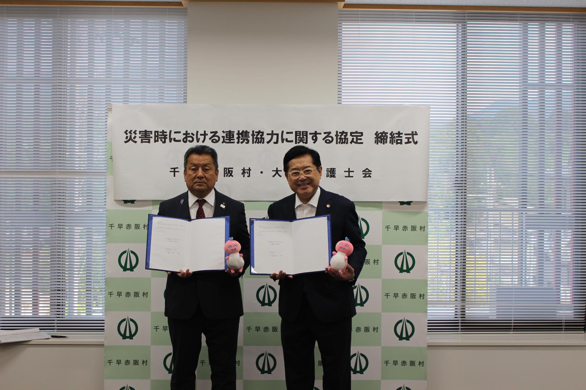 協定書を持って二人並んで